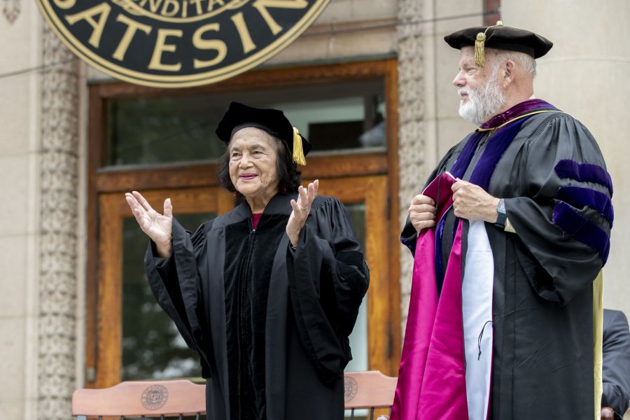 Dolores Huerta acknowledges applause as she's given an honorary degree at Opening Convocation. Ready to present her with the honorary hood is Michael Murray, Phillips Professor of Economics. (Phyllis Graber Jensen/Bates College)