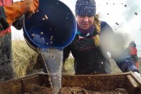 During the screening process, Maya McDonough ’22 winces and mud splashes as Jinzhi Wei ’20 pours water onto excavated soil. (Tim Leach '99 for Bates College)
