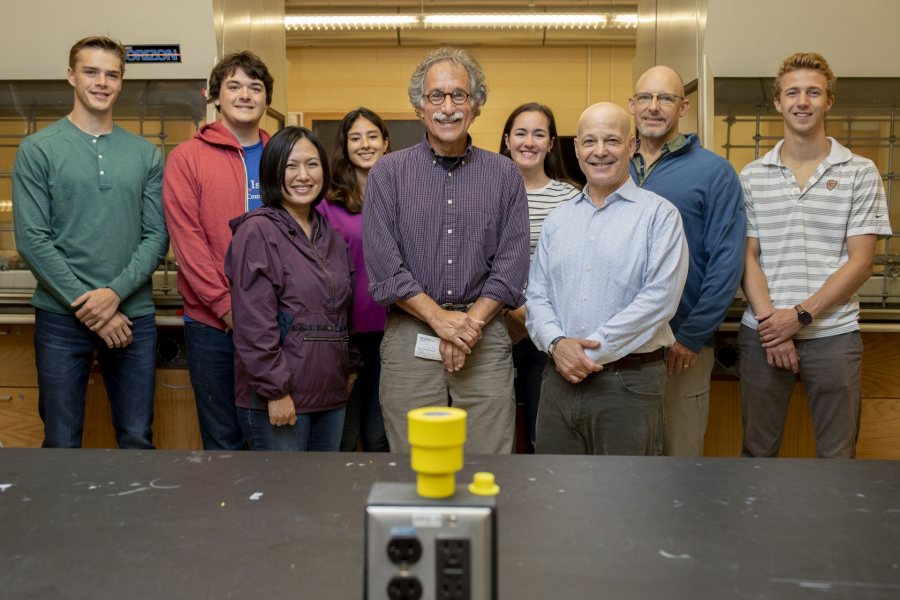 Dana Professor of Chemistry Tom Wenzel (center) is flanked by donors Jim Weissman ’84 and Kyoko Weissman as they celebrate the establishment in September of the Thomas J. Wenzel Endowed Fund for Undergraduate Chemistry Research. Joining them in Dana Chemistry Hall are, from left, Jake O’Hara ’21, Nick Jones ’20, Shanzeh Rauf ’21, Maddie Murphy ’20, Associate Professor of Chemistry Matt Côté, and Owen Bailey ’22.  (Phyllis Graber Jensen/Bates College)