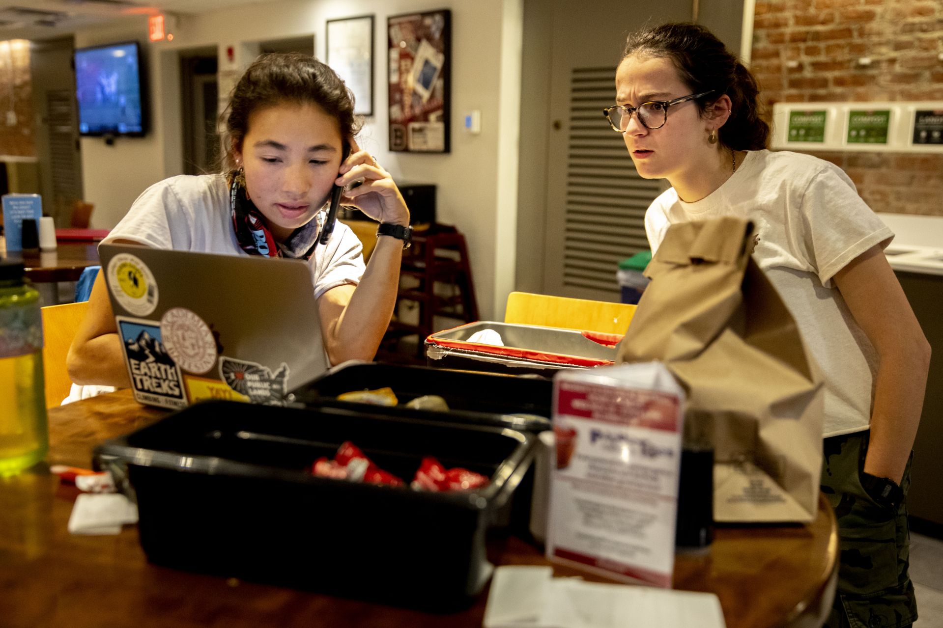 Bates Den Deliver Service in operation between 9-10 p.m. on Tuesday, Nov. 19, 2019. Serving as the CEO this year is Grace Warder '20 of NYC, and taking the orders and making the deliveries tonight are Olivia Kranefuss '22 of Madison, N.J.,in the corduroy shirt and Elly Beckerman '22 of Washington, D.C., in glasses. All three women are environmental studies majors. Roman Hudgins of Dining Services is shown handing over an order to Kranefuss who bikes to her fist delivery at Parker, passing through the Library Quad, both on the Quad and the Library Well. Beckerman makes a delivery to Frye Street and bikes across the Historic Quad to get there. And Harley Rinehart, in gray shirt and garnet hat takes the order from Kranefuss after she waits in line to place it.