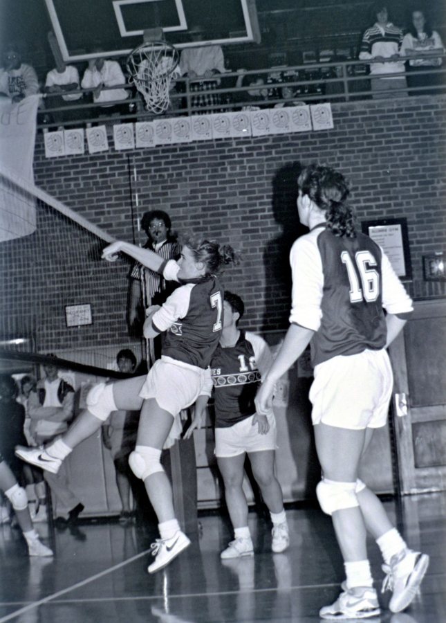 Julie Roche Simplicio '91 spikes the ball while All-American Rachel Clayton '90 (No. 16) looks on. (Scott Pim '93)