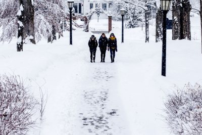 Students navigate a snowy campus this March Monday morning in Maine. From left, seniors Daisy Diamond, Olivia Fried, and Lily Kip navigate the Historic Quad during a March snowfall.