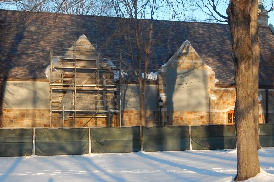 Plastic sheeting and plywood protect the Gomes Chapel window openings while the stained-glass windows are being restored. (Doug Hubley/Bates College)