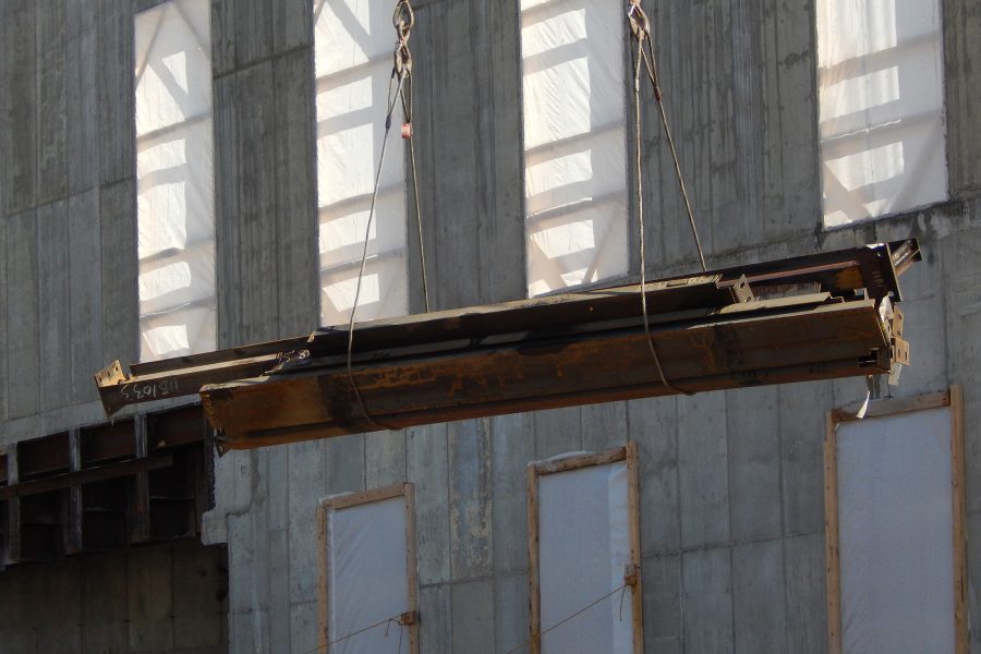 A bundle of structural steel components drifts past the west wall of the Bonney Science Center en route to the building top. (Doug Hubley/Bates College)