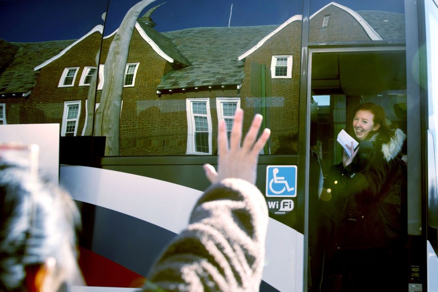 Students gather in front of Chase Hall to take two buses that will take them on the first leg of their trips home. One is a Concord Trailways bus, regularly scheduled daily for 3:30 p.m. pickup. The other is a bus chartered by the College.