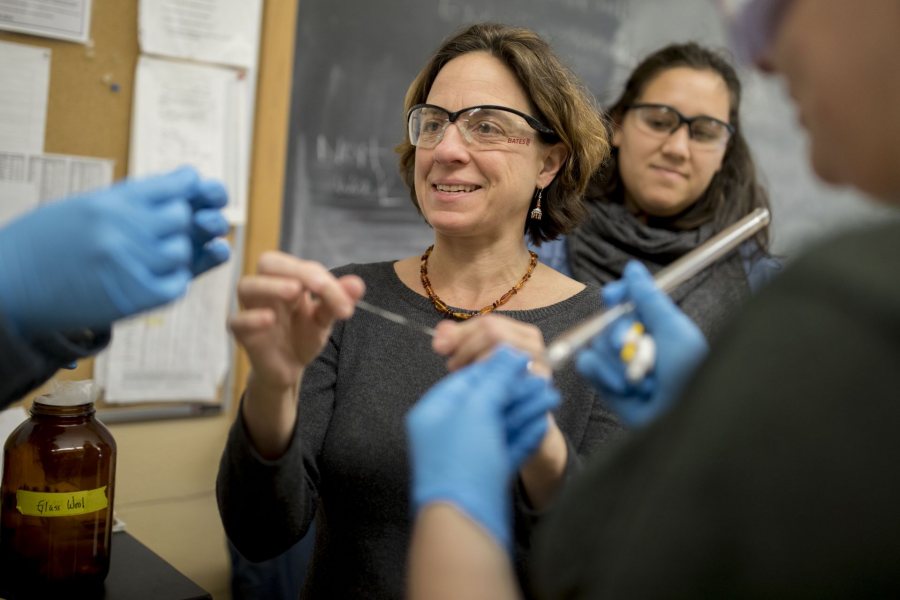 Associate Professor of Chemistry and Biochemistry Jennifer Koviach-Côté, displays glass wool in a laboratory for students in Organic Chemistry 217, where she asked them to separate two essential oils. Behind her is the course’s teaching assistant Cara Starnbach ’17 of Needham, Mass.