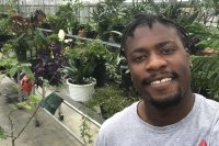 Bates associate head coach of track and field Curtis Johnson takes a selfie in the Bates greenhouse.