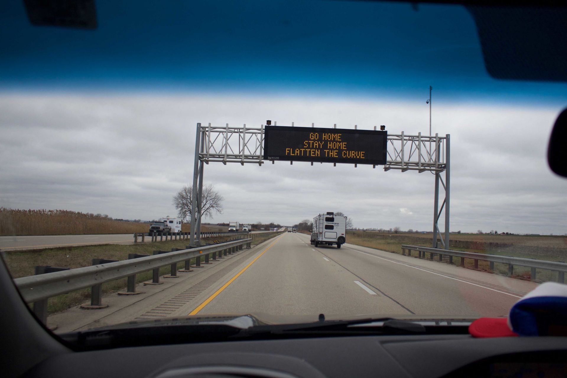 An Indiana Department of Transportation sign on I-80 tells drivers to “Go Home, Stay Home, Flatten The Curve," on March 31, 2020. (Photograph by Jackson Sell '22)