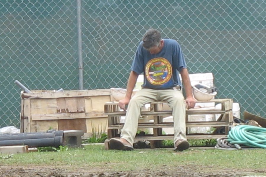 Rest, stop: A worker rests near the construction fence. (Doug Hubley/Bates College)