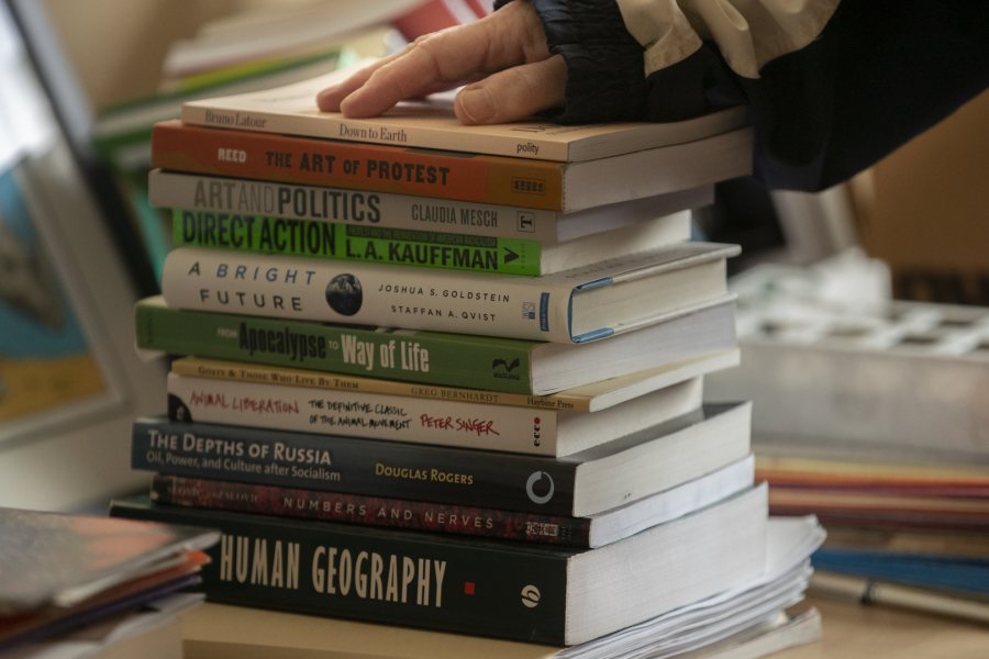 Costlow pauses for a moment with a stack of books she's packing in her office. (Phyllis Graber Jensen/Bates College)