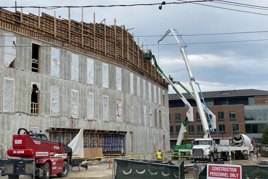 The pumper is standing by to place wall concrete and Consigli employees are in position at the top of the wall forms in this June 5 view. (Geoff Swift/Bates College)