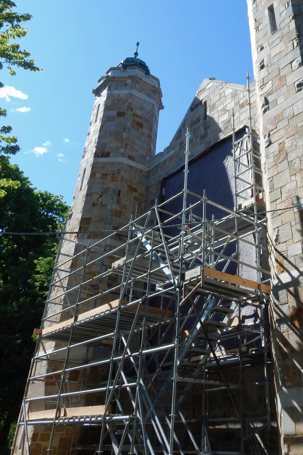 Shown on June 8, staging and protective tarps conceal the opening for the stained glass window at the north wall of the Gomes Chapel. (Doug Hubley/Bates College)
