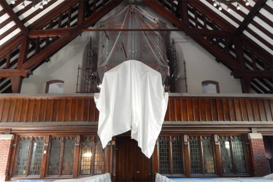 Plastic sheets protect one of the chapel's two organs (including the pipes on the facade of the rear gallery) from dust raised during the renovation. (Doug Hubley/Bates College)
