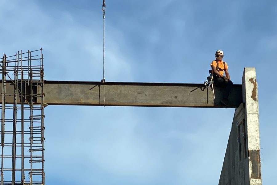 On June 123, a steelworker perched on a just-placed beam looks to a co-worker for a signal. (Geoff Swift/Bates College)