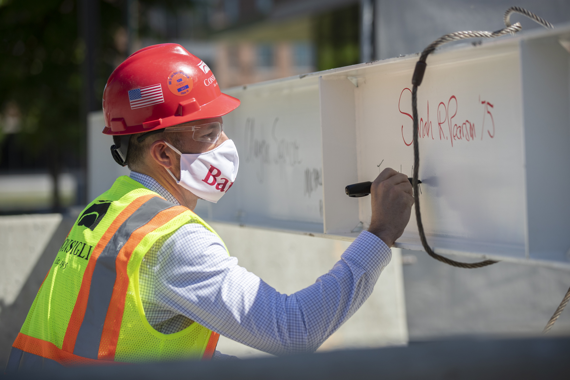 Images from the topping off event on May 16, 2020, at the Bonney Science Center, featuring the final major piece of structural steel being installed on the building. In keeping with tradition, a small spruce tree was attached to the beam fluttered plus a Bates banner and the American flag. The beam has the signatures of Bates participants and members of the Consigli construction crew.Participants: Michael W. Bonney ’80, P’09, P’12, P’15Alison Grott Bonney ’80, P’09, P’12, P’15Sarah R. Pearson ’75, Vice President for College AdvancementA. Clayton Spencer, PresidentChris Streifel, Facilities Services Project ManagerGeoff Swift, Vice President for Finance and Administration and TreasurerPam Wichroski, Director of Capital Planning and ConstructionDave Thomas, Consigli Construction Michael Hinchcliffe, Payette Architecture Firm Bob Schaeffner, Payette Architecture Firm