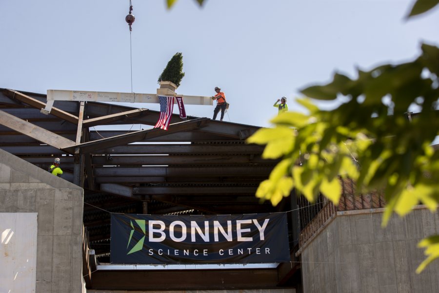 Images from the topping off event on May 16, 2020, at the Bonney Science Center, featuring the final major piece of structural steel being installed on the building. In keeping with tradition, a small spruce tree was attached to the beam fluttered plus a Bates banner and the American flag. The beam has the signatures of Bates participants and members of the Consigli construction crew.Participants: Michael W. Bonney ’80, P’09, P’12, P’15Alison Grott Bonney ’80, P’09, P’12, P’15Sarah R. Pearson ’75, Vice President for College AdvancementA. Clayton Spencer, PresidentChris Streifel, Facilities Services Project ManagerGeoff Swift, Vice President for Finance and Administration and TreasurerPam Wichroski, Director of Capital Planning and ConstructionDave Thomas, Consigli Construction Michael Hinchcliffe, Payette Architecture Firm Bob Schaeffner, Payette Architecture Firm