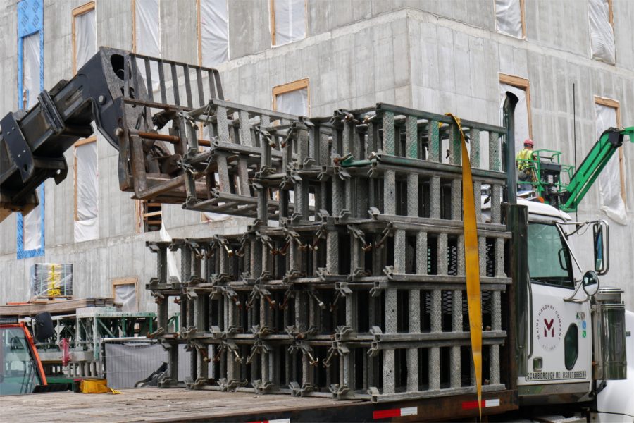 Shown being unloaded by a forklift, components for the Hydro Mobile staging — so-called mast-climbing work platforms that are hydraulically raised and lowered — showed up on July 13. They were delivered by Maine Masonry, which will use them for bricklaying. (Doug Hubley/Bates College)