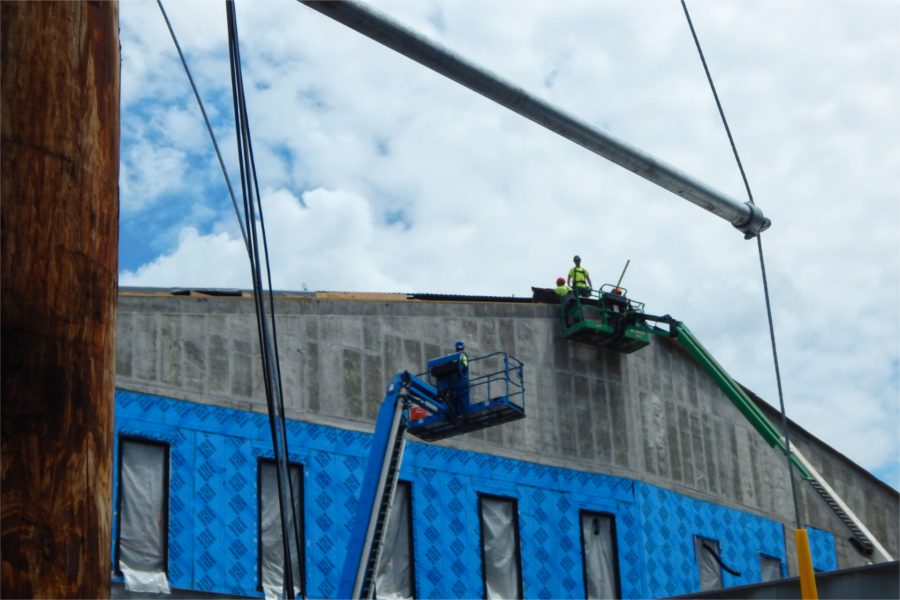 Roofers applying a temporary weather barrier on the south side of the science center. (Doug Hubley/Bates College)