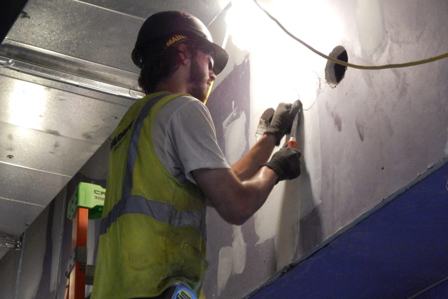 Preparing to cut a hole for a conduit on the first floor of the science center. (Doug Hubley/Bates College)