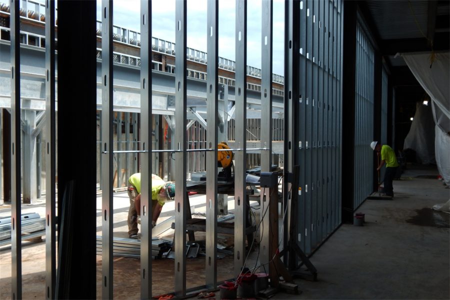 Wall framers at work in the Bonney Center penthouse on July 13. The area at left, which will contain a generator and air chillers, will remain open to the elements, while the rest of this fourth-floor space will be enclosed. (Doug Hubley/Bates College)