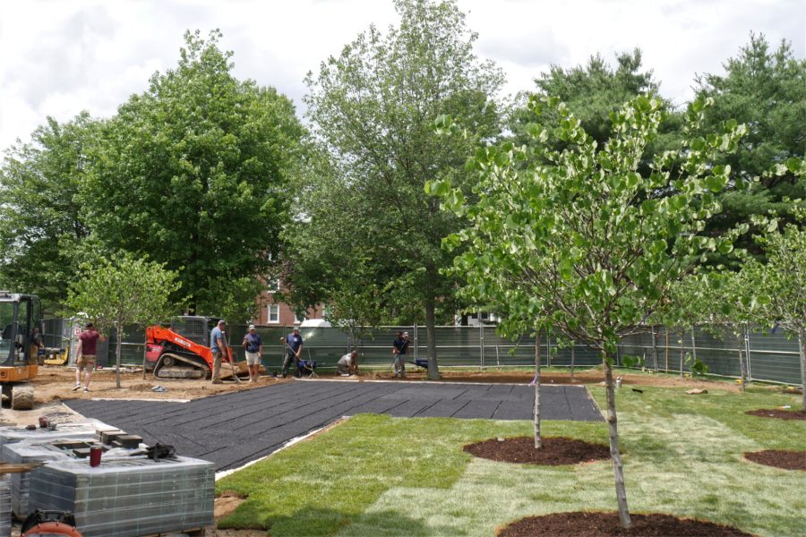 A crew from Carrier Lawn Care & Landscaping of Lewiston lays sod at the Veterans Plaza site. On pallets at left are asphalt pavers for the project. (Doug Hubley/Bates College)