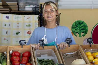 "Living and working in the Lewiston community has taught me a lot about what it really means to invest in the place one calls home because I’ve had the opportunity to work so closely with individuals who have committed themselves to connecting community members to food, land, and each other.”—Religious studies major Anna Maheu ’21 of New York City, photographed on Campus Avenue with the Good Food Bus, a mobile market that brings locally sourced produce to various neighborhoods.Maheu’s Harward Summer Civic Fellowship with the Nutrition Center is funded through the Harward Center for Community Partnerships @harwardcenter.A food security organization for food insecure and otherwise vulnerable families, the Nutrition Center’s integrated programs include urban community gardens, children’s gardening and cooking programs, cooking and nutrition education programs, youth leadership programs, food access initiatives, and a food pantry.Maheu’s work this summer consists of supporting the Nutrition Centers various gardens throughout Lewiston-Auburn, maintaining educational gardens, assisting the food pantry in its efforts to adapt to COVID-19 through food deliveries, and the Good Food Bus.Maheu’s hands-on experience, coupled with support provided by the Nutrition Center’s staff members, has provided her with a “ground-level look at the myriad ways that food justice and access is pursued,” she says, and “has reaffirmed how fundamental food and soil are to the lives we live, the power structures we must work against, and the relationships we cultivate.”Thanks to the Nutrition Center, she also has had the chance to grow much of her own food this summer. “I will take these sustaining and sustainable capacities with me into my life after Bates.”