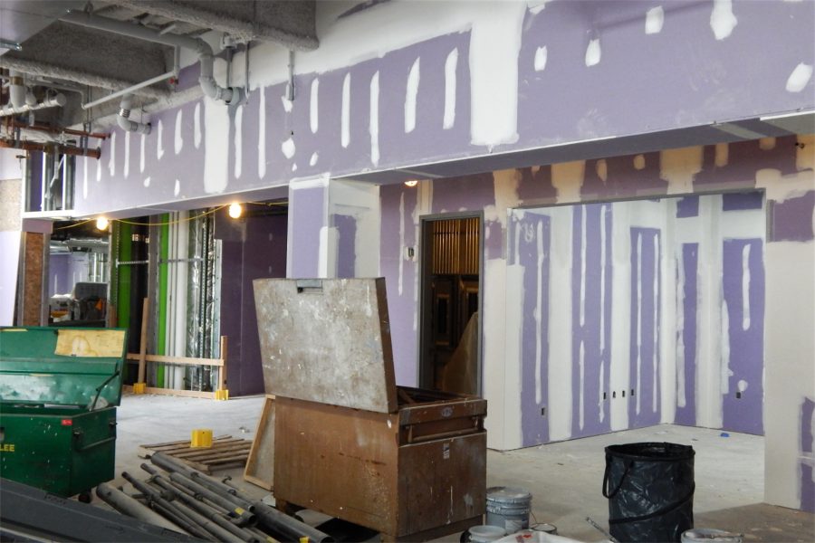 A first-floor lobby in the science center. Notice, at upper left, the gray acoustic treatment on beams and pipes. It will remain visible as a decor element. (Doug Hubley/Bates College)