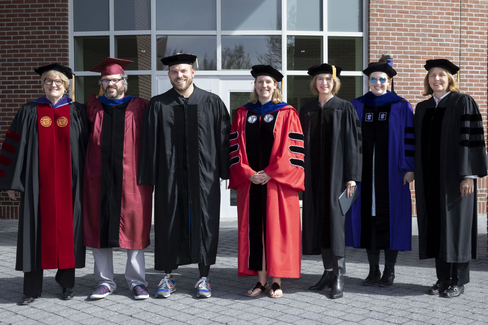 Bates College 2019 Commencement  (the one hundred and fifty-third) on the Historic Quad, at which Travis Mills receives an Doctor of Humane Letter. Placing the collar on Mills is the college's mace bearer, Charles Franklin Phillips Professor of EconomicsMichael Murray.