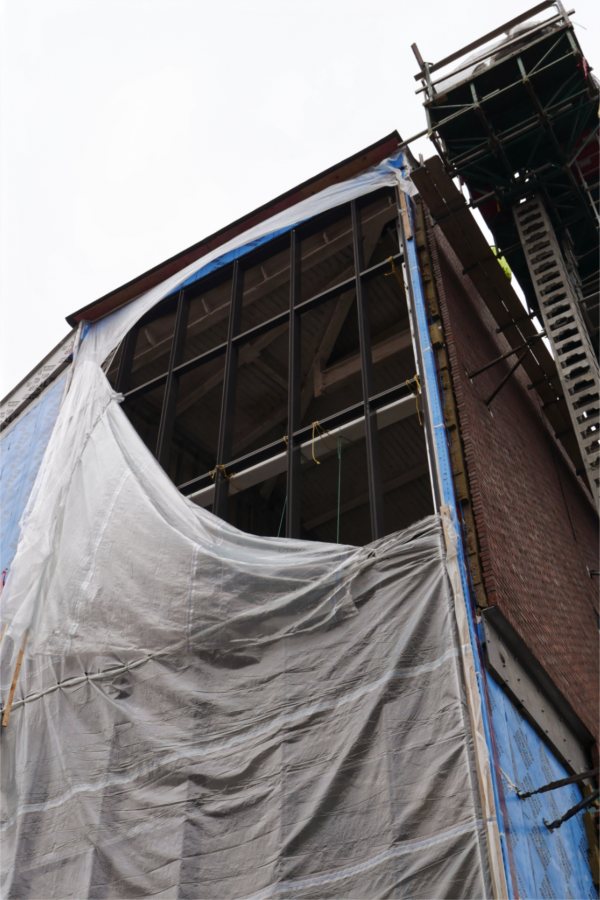 The opening in the poly weather shield reveals the steel structure in place to support the glass "curtain wall" of the Beacon, a signature feature of the Bonney building. (Doug Hubley/Bates College)