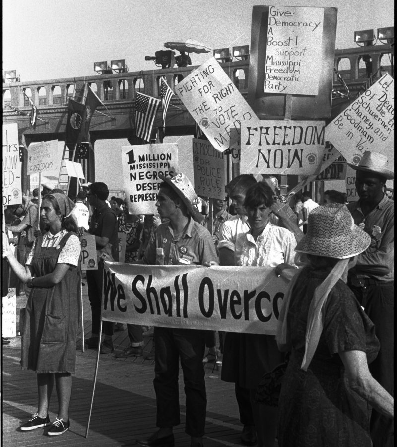 

Leffler, Warren K, photographer. Black and white supporters of the Mississippi Freedom Democratic Party holding signs in front of the convention hall at theDemocratic National Convention, Atlantic City, New Jersey; one sign reads "Fighting for the right to vote MFDP" / WKL. Atlantic City New Jersey, 1964. Photograph. https://www.loc.gov/item/2014645515/.