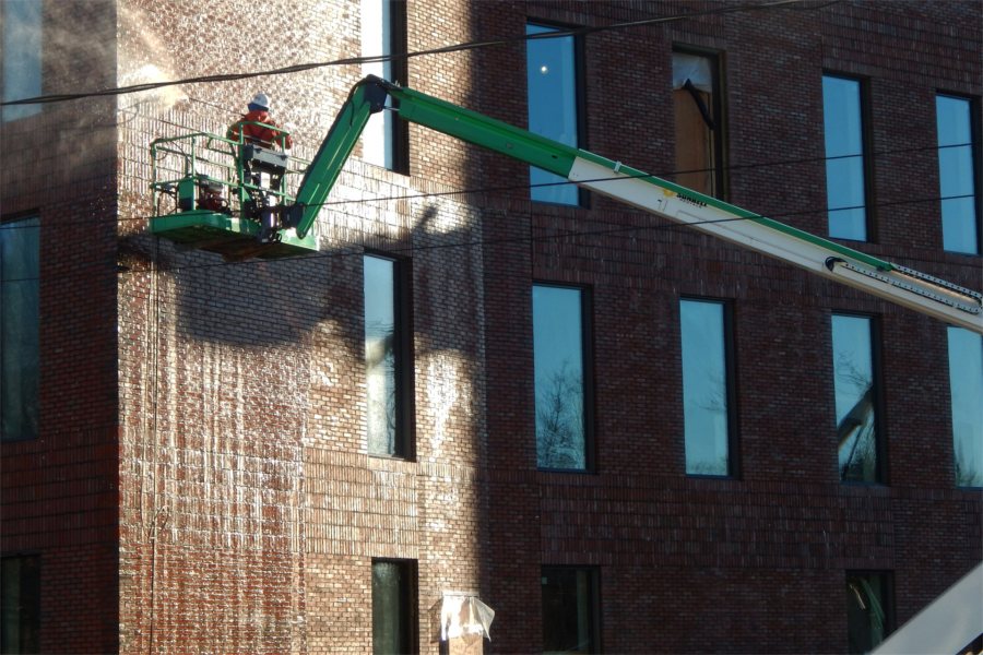 Washing brickwork on the science center's south wall. (Doug Hubley/Bates College)