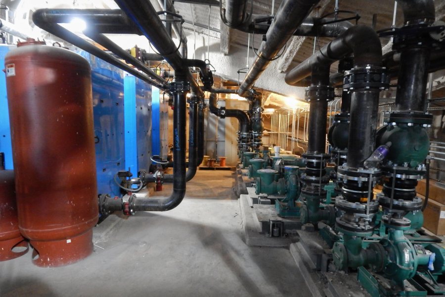 Located in the Bonney center penthouse, the blue boilers at left will heat water for both domestic use (handwashing, etc.) and space heating. At right is a battery of water pumps. (Doug Hubley/Bates College)