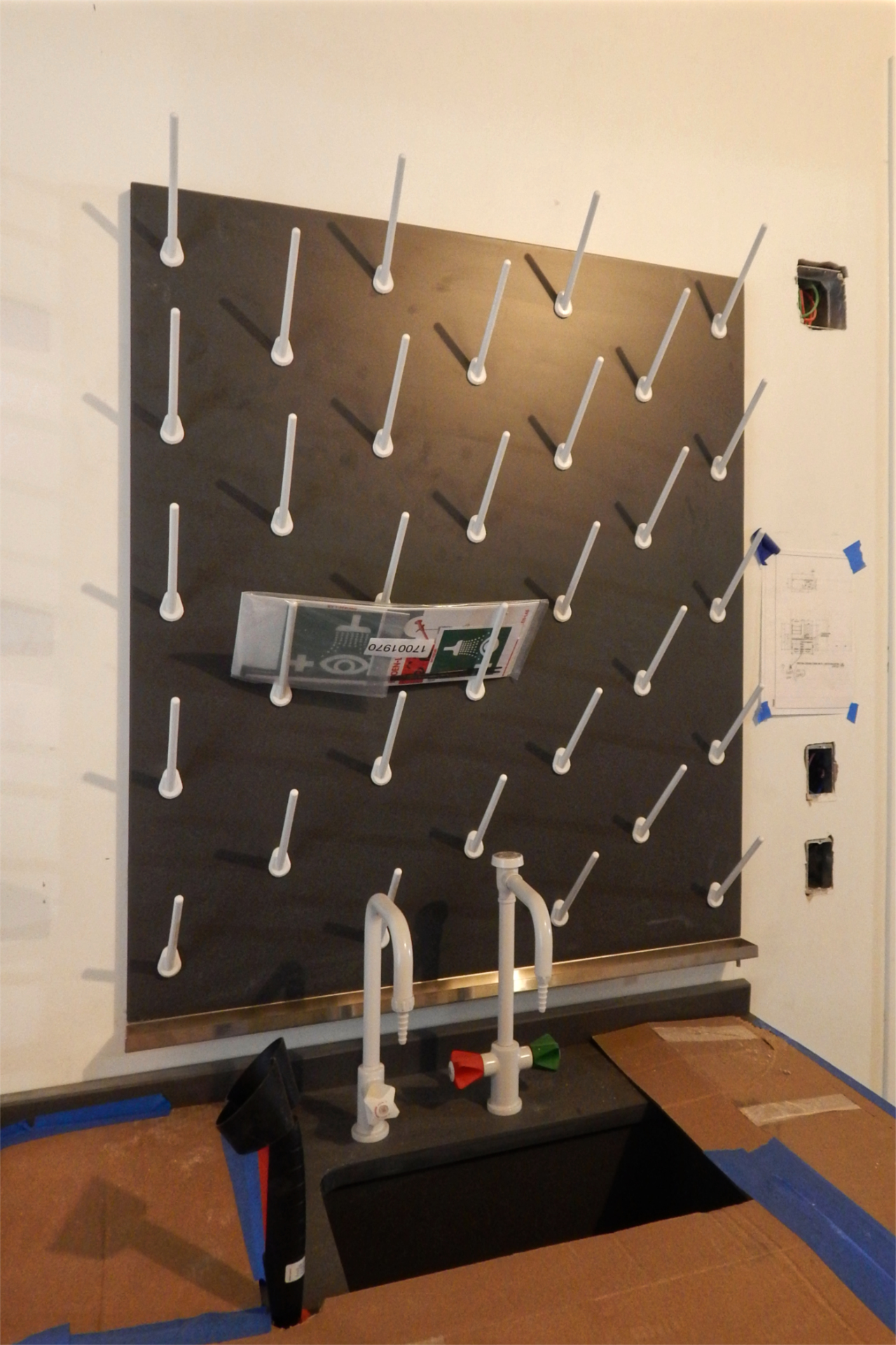 This pegboard will be used to dry lab vessels after washing. Note the gutter at the bottom of the board and its little drain at the right-hand end. (Doug Hubley/Bates College)