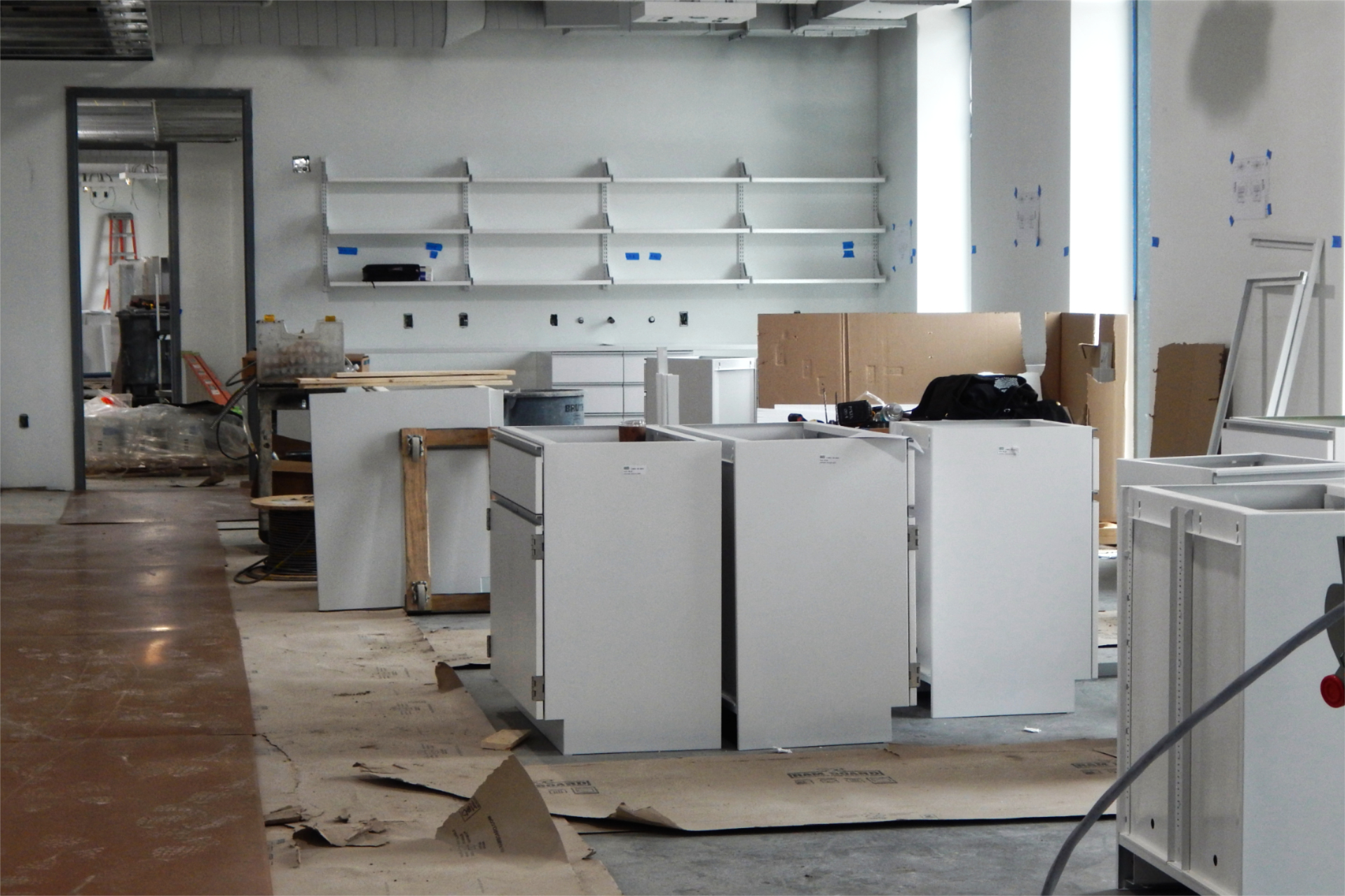 Cabinets await placement in a second-floor research lab that will be shared by faculty in biology and biochemistry. White is the permanent wall paint color here, but more coats will follow the initial top coat that's shown. (Doug Hubley/Bates College)