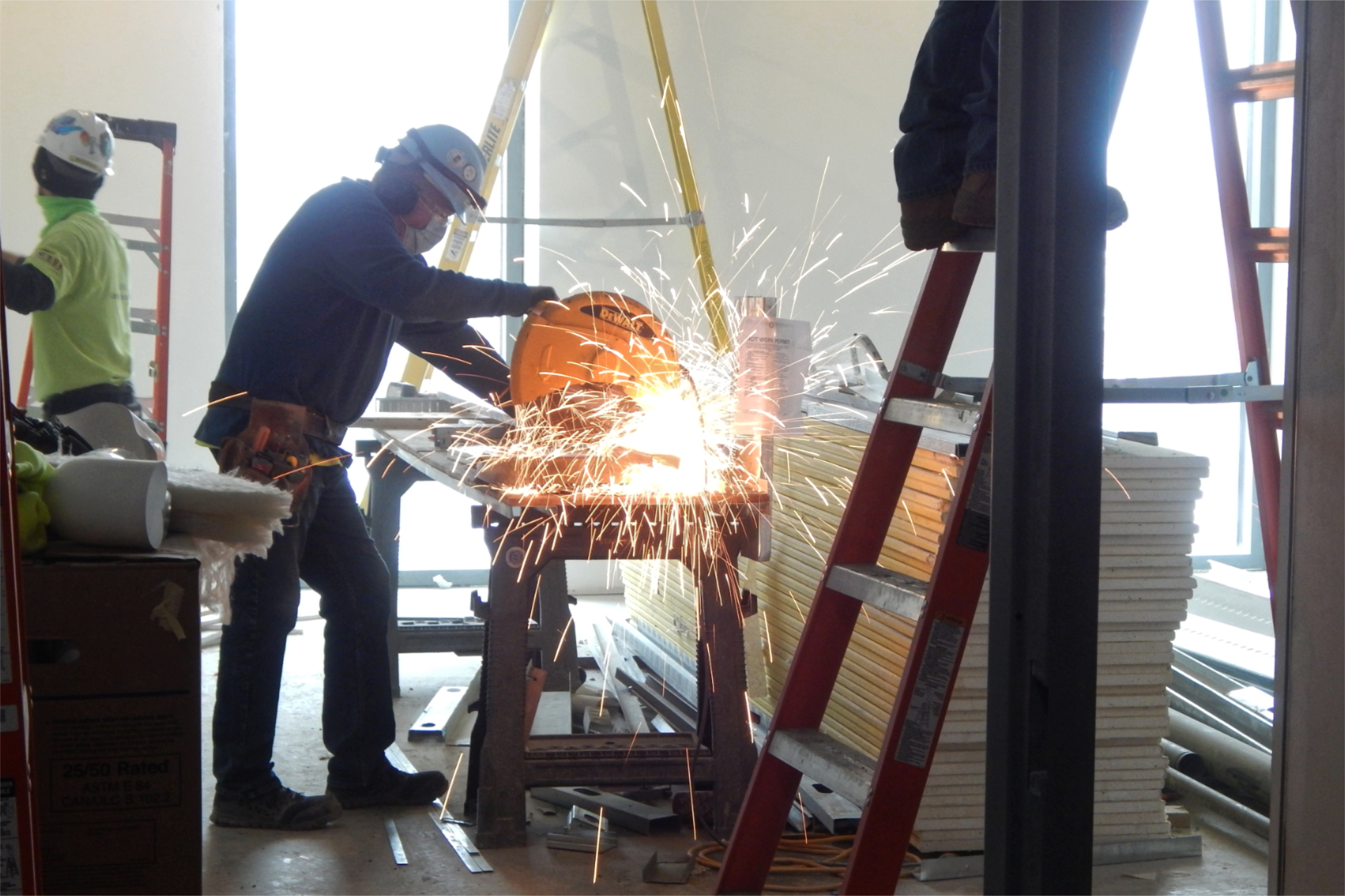 A Roland's Drywall employee cuts a section of metal wall framing. (Doug Hubley/Bates College)