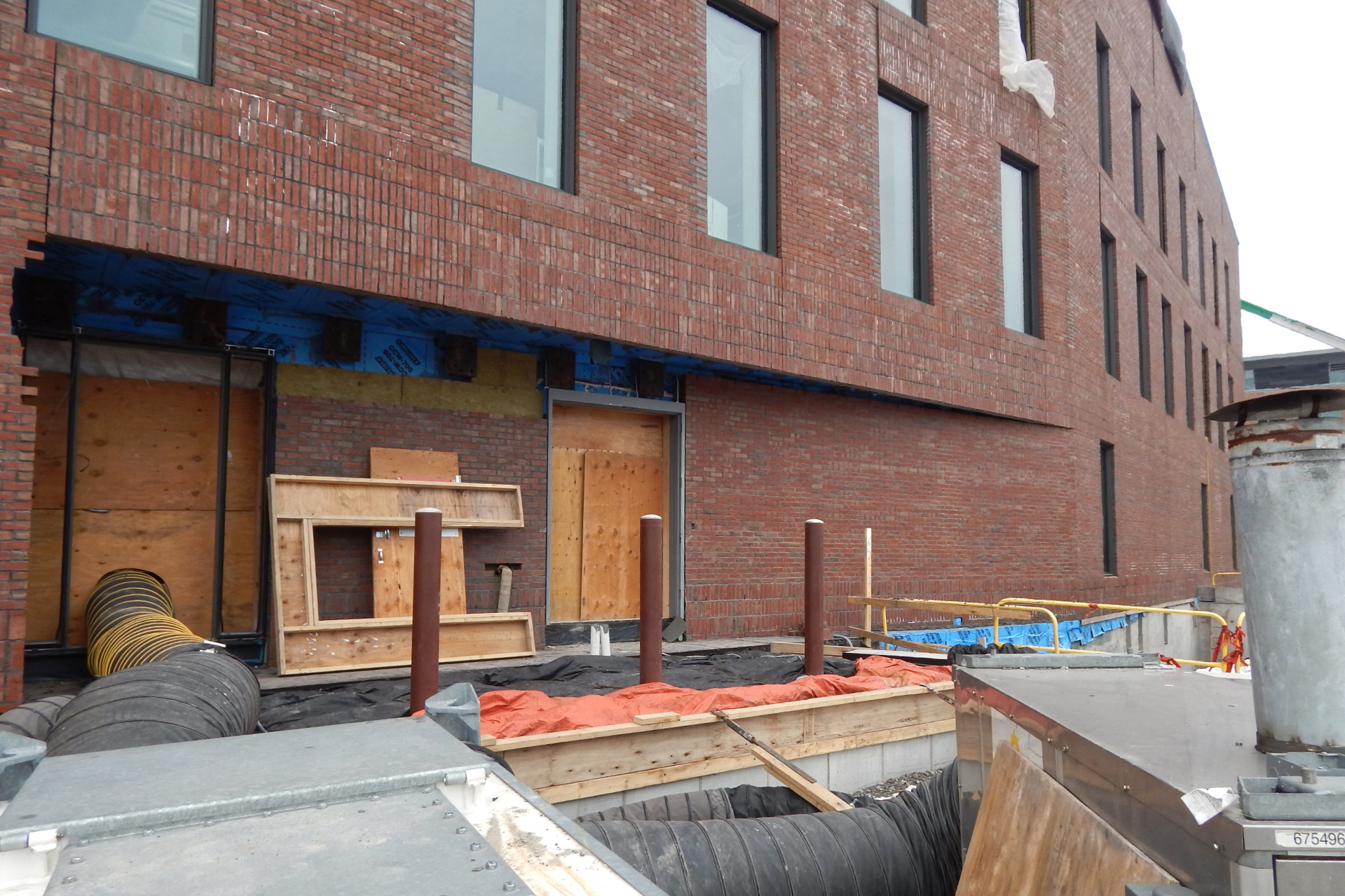 A loading dock under construction on the science center's south side. The black and orange fabrics are blankets to keep concrete warm as it cures. The accordion tube brings heat into the building from the temporary space heater in the foreground. (Doug Hubley/Bates College)