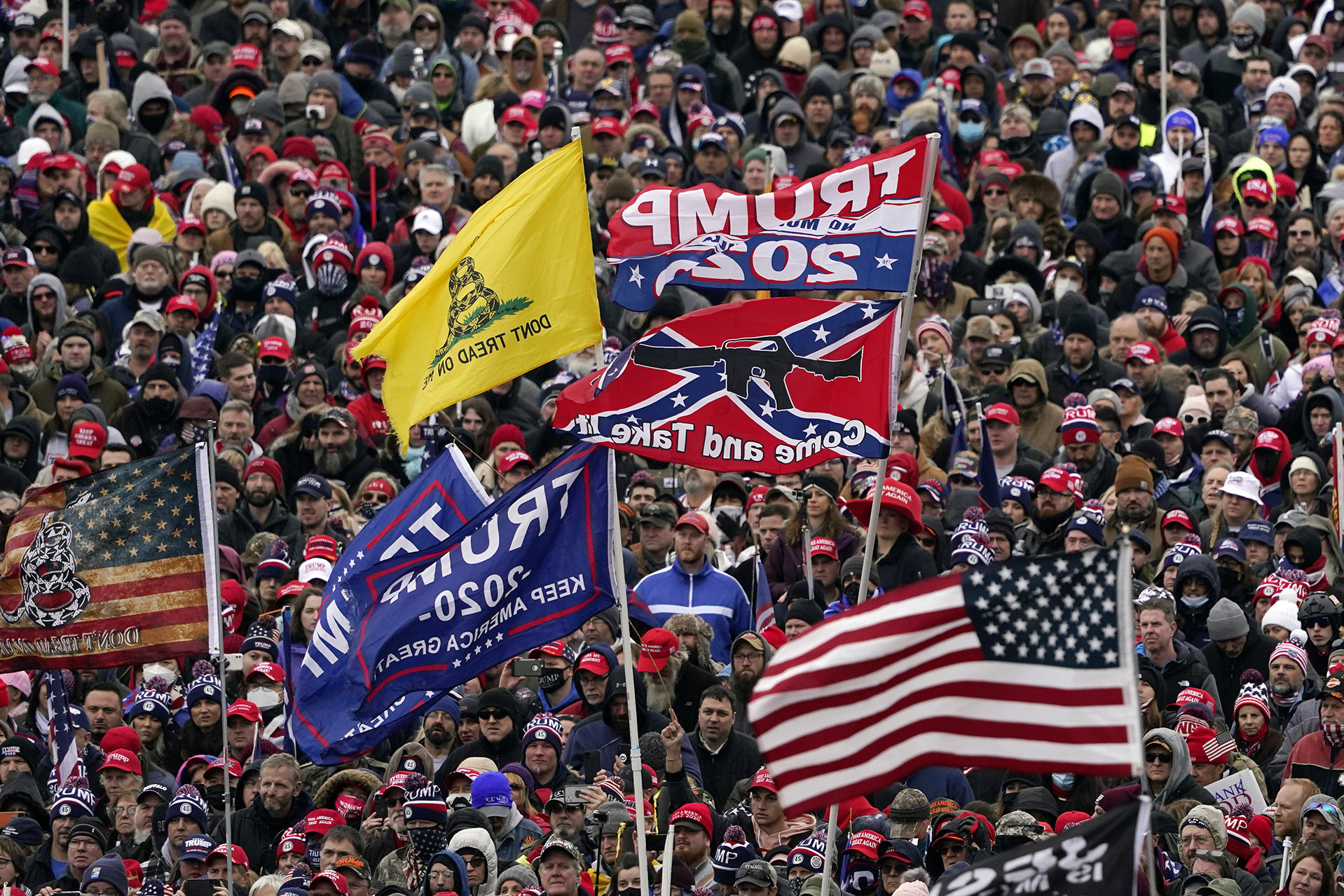 FILE In this Wednesday, Jan. 6, 2021, file photo, supporters listen as President Donald Trump speaks as a Confederate-themed and other flags flutter in the wind during a rally in Washington. War-like imagery has begun to take hold in mainstream Republican political circles in the wake of the deadly attack on the U.S. Capitol, with some elected officials and party leaders rejecting calls to tone down their rhetoric contemplating a second civil war. (AP Photo/Evan Vucci, File)