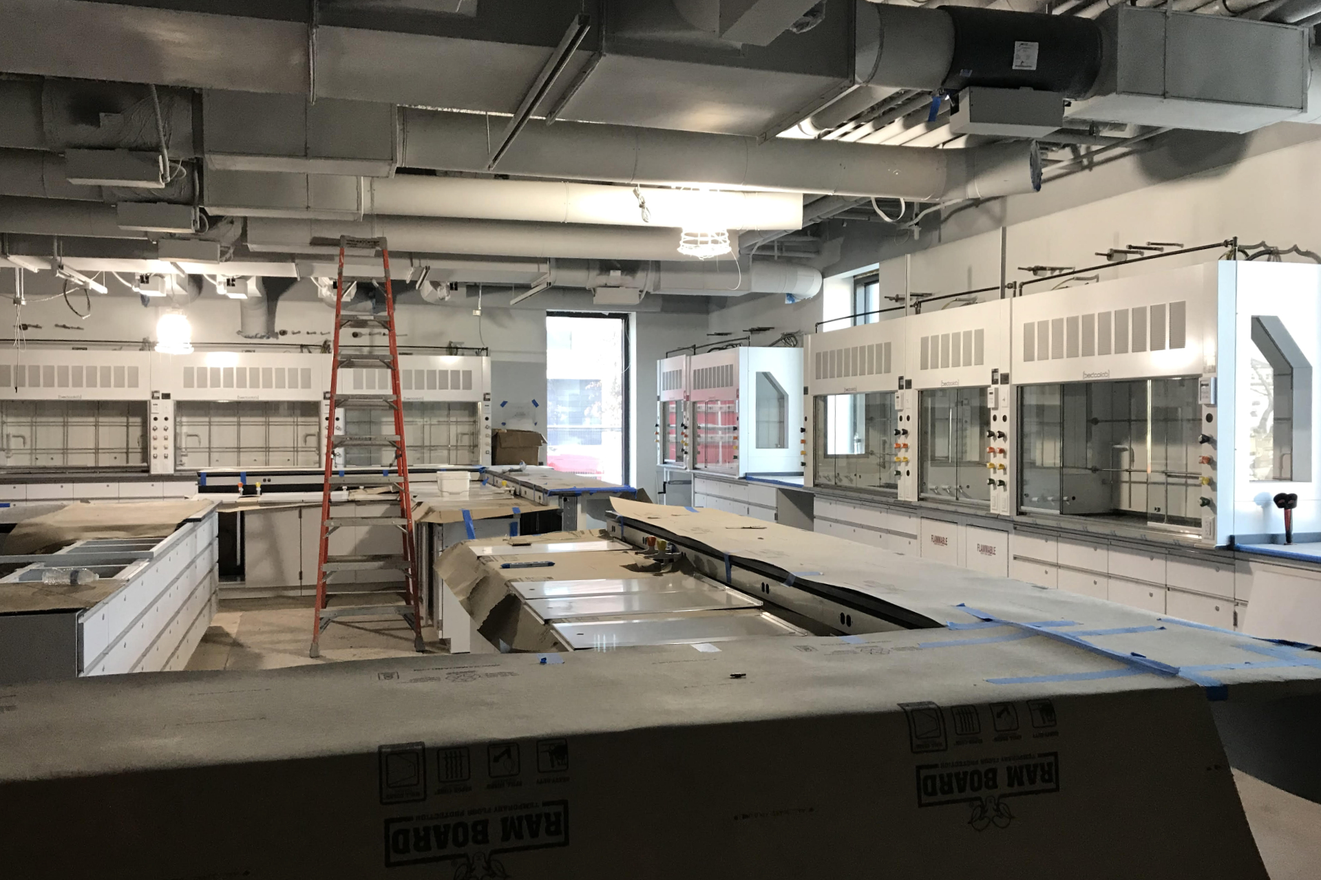 Glass-fronted fume hoods are among the science equipment newly installed in this first-floor biology lab. Students will work at the counter at center, with their professor using the smaller counter at left. (Courtesy of Consigl Construction)