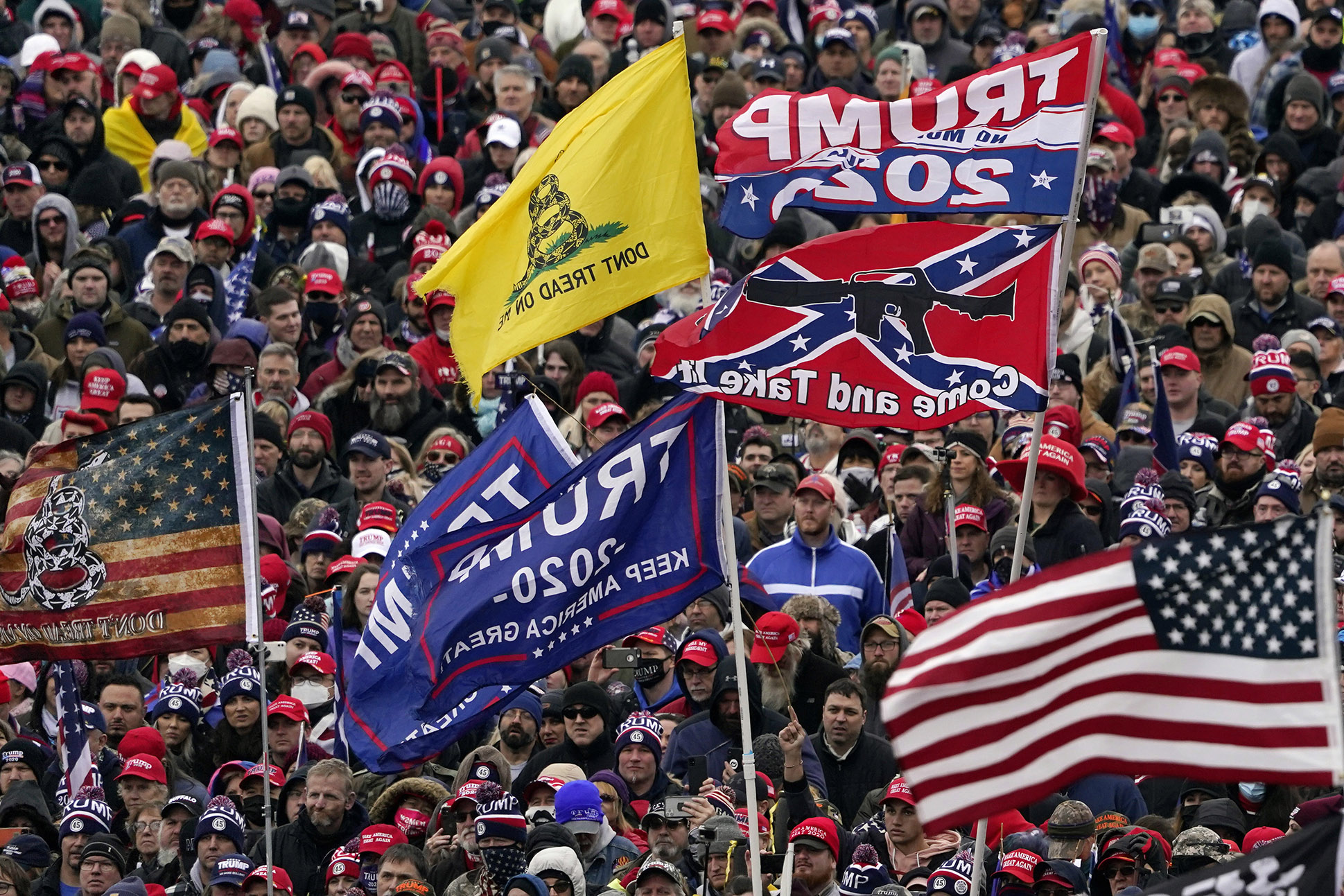 FILE In this Wednesday, Jan. 6, 2021, file photo, supporters listen as President Donald Trump speaks as a Confederate-themed and other flags flutter in the wind during a rally in Washington. War-like imagery has begun to take hold in mainstream Republican political circles in the wake of the deadly attack on the U.S. Capitol, with some elected officials and party leaders rejecting calls to tone down their rhetoric contemplating a second civil war. (AP Photo/Evan Vucci, File)