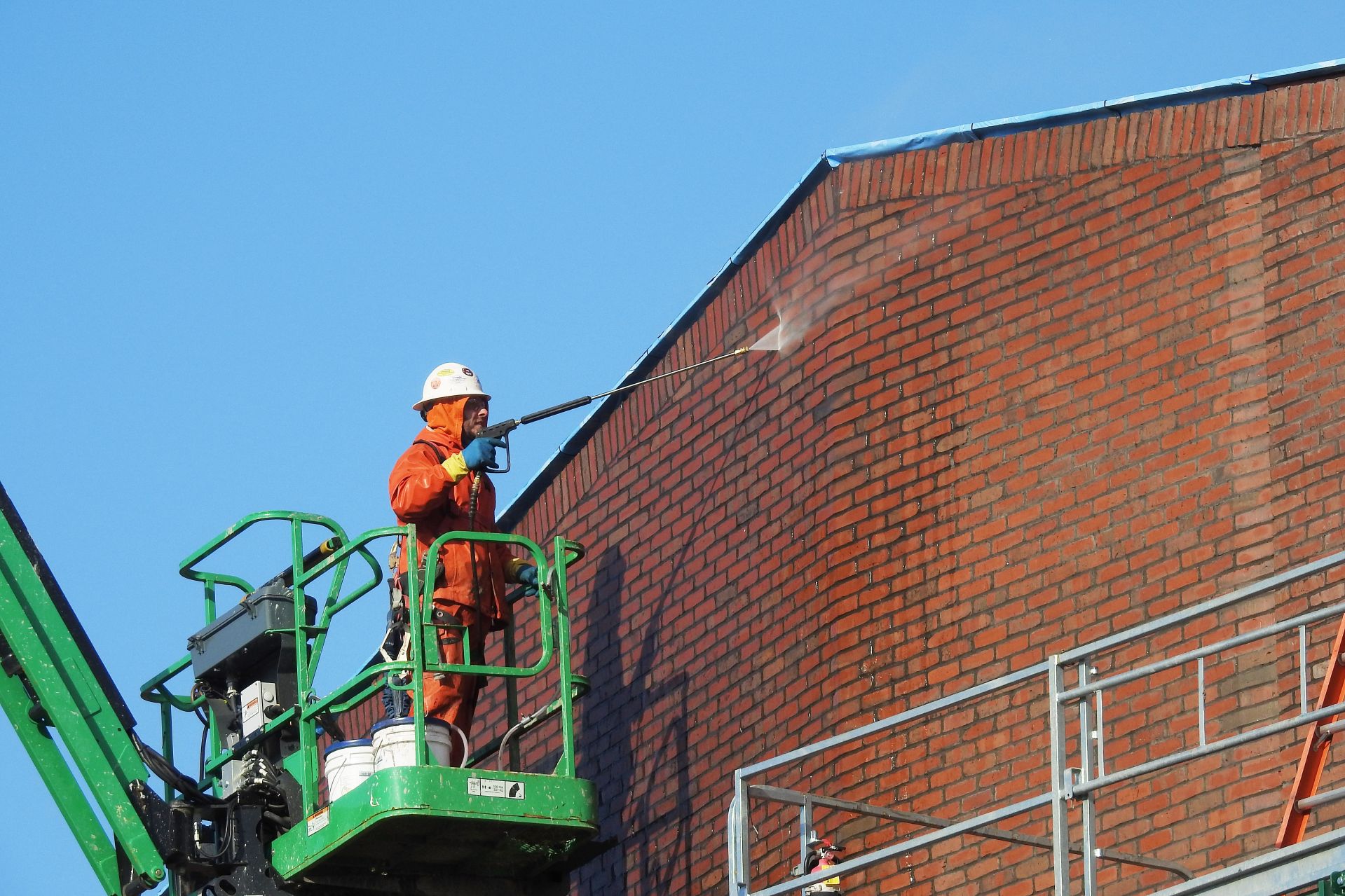 Images of interior spaces (lounges, classrooms, labs, stairwells) and exteriors of the Bonney Science Center.
A worker power washes brick exterior.