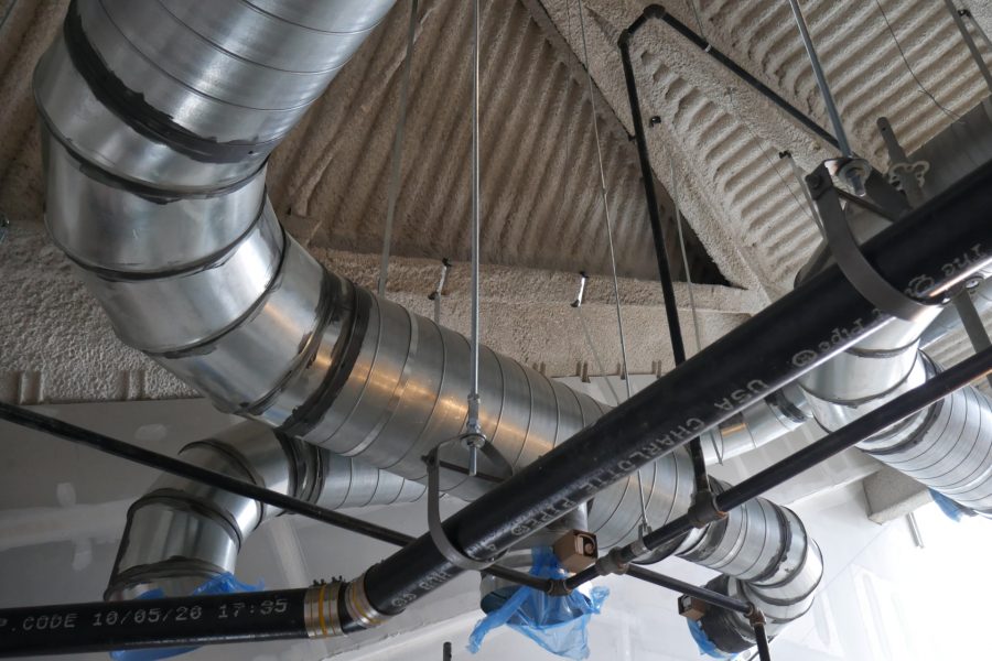 Ventilation ducts and a stormwater drainpipe criss-cross the ceiling of a third-floor classroom. (Doug Hubley/Bates College)