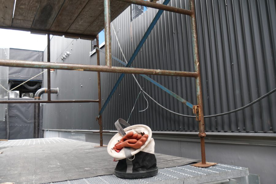 With a collapsible bucket and an electrician's rubber gloves as centerpiece, this view of the Bonney center's rooftop mechanical well also shows newly placed metal wall covering, at right. (Doug Hubley/Bates College)