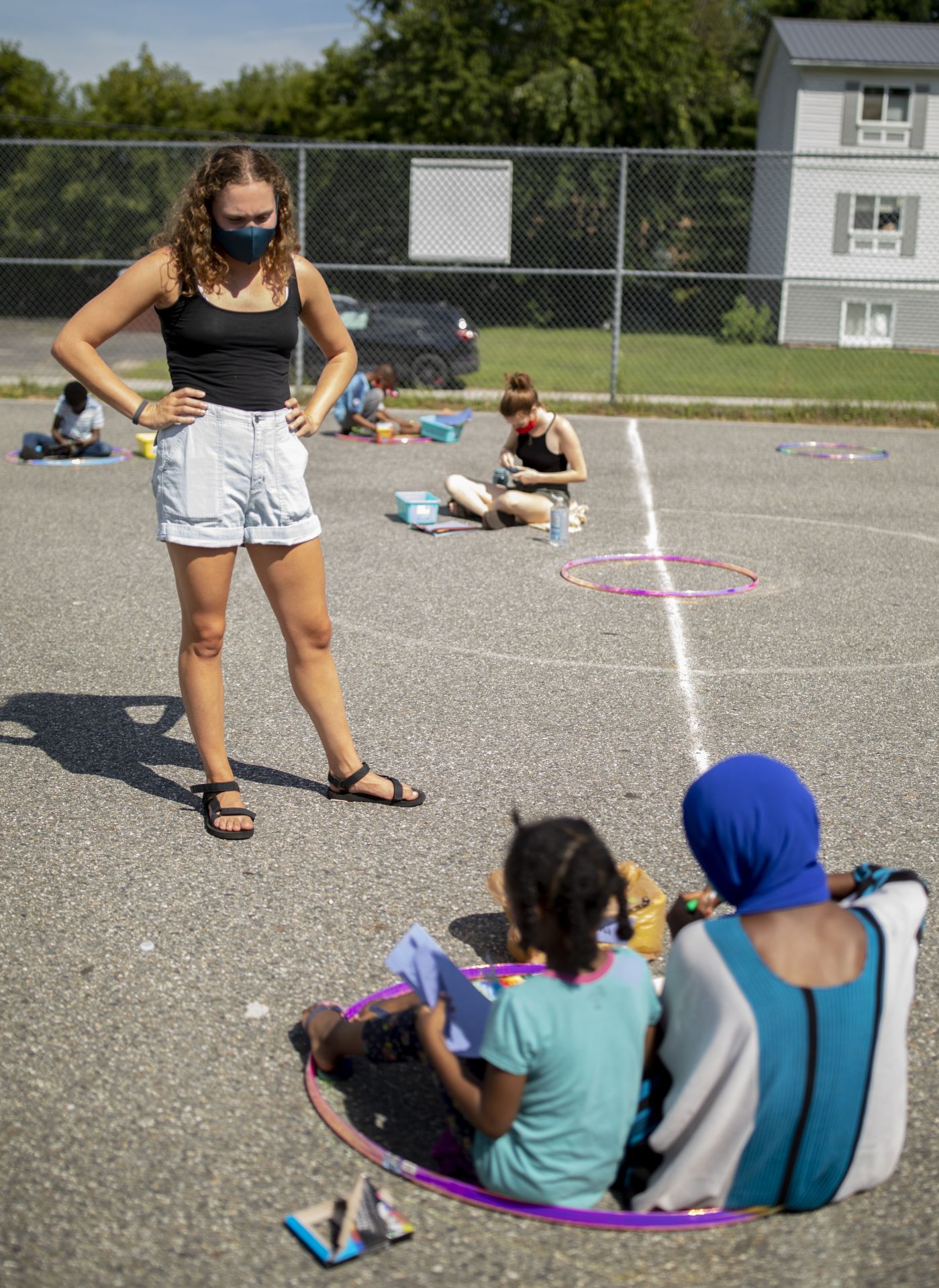 Psychology major Hannah Golub ’21 of Bellaire, Texas, (in maroon shorts and hat) and religious studies major Anna Maheu ’21 of New York City, work in the garden at Lewiston's Hillview Housing, where they picked raspberries.