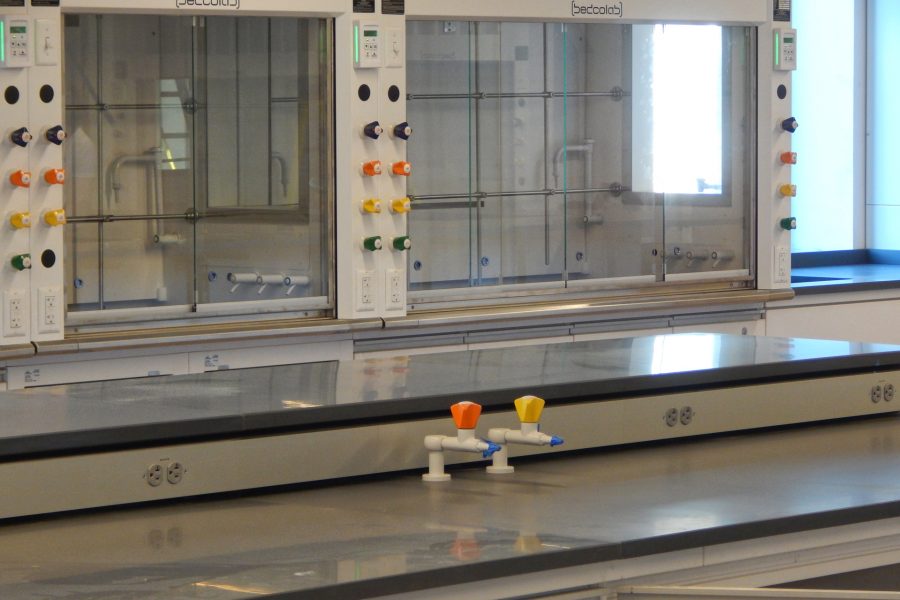 Gas spigots on a bench in a biochemistry lab on the first floor of the science center. In the background are fume hoods. (Doug Hubley/Bates College)