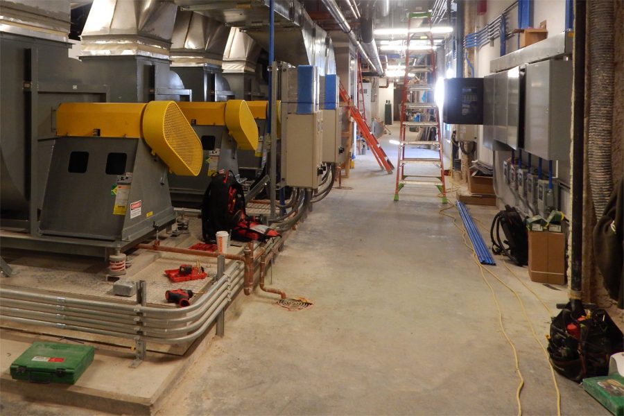 As the installation of mechanical equipment nears completion, the Bonney Center penthouse is much neater than it was a few weeks ago. The yellow and gray machines at left are air-exhaust fans. (Doug Hubley/Bates College)