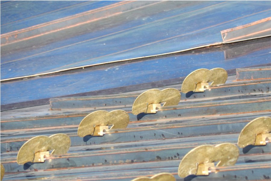 Fastened to the standing seams of the ContinentalBronze panels, these snow guards will help keep sheets of ice and snow from sliding off the Bonney Center roof. (Doug Hubley/Bates College)