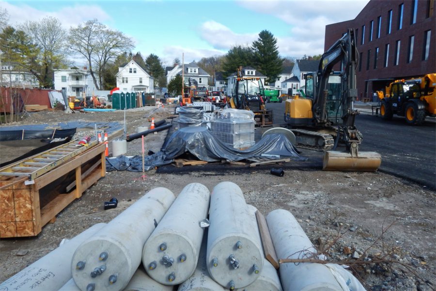 Supplies for site work, including lamppost bases (foreground), drain tiles, and curbstones, are stockpiled on the south side of the Bonney Center. (Doug Hubley/Bates College)