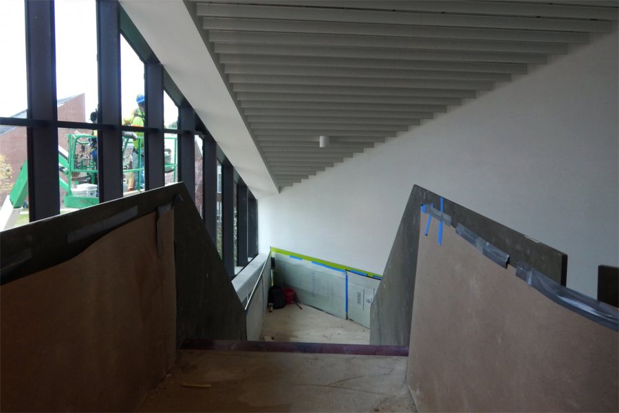 The head of the Monumental Stair, accessed from the third floor. The workers on the lift outside are applying trim to the roof edge. (Doug Hubley/Bates College)