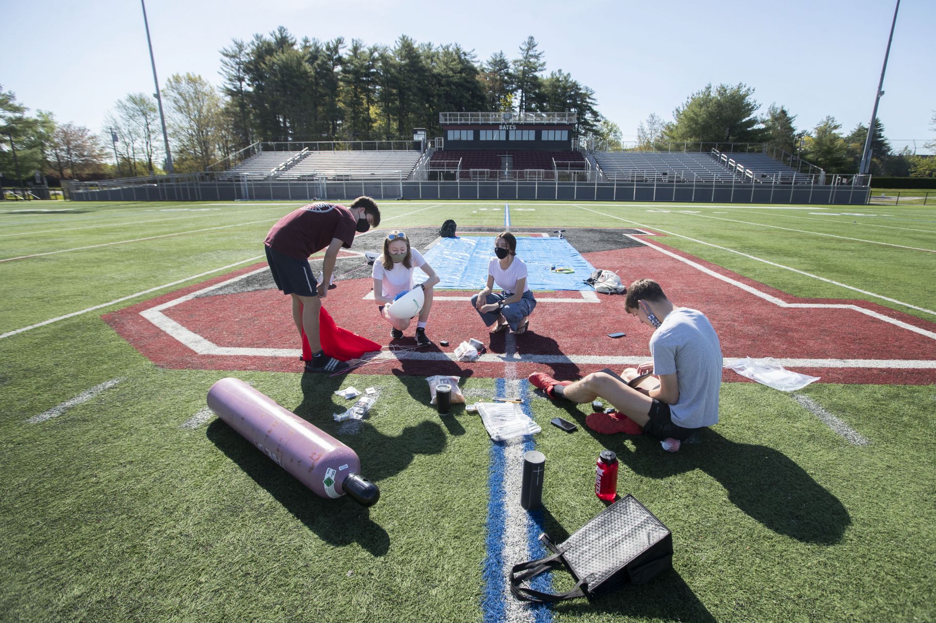 Members of the High Altitude Ballooning Club lay out their gear on May 15 in preparation for a launch from Garcelon Field. (Phyllis Graber Jensen/Bates College)