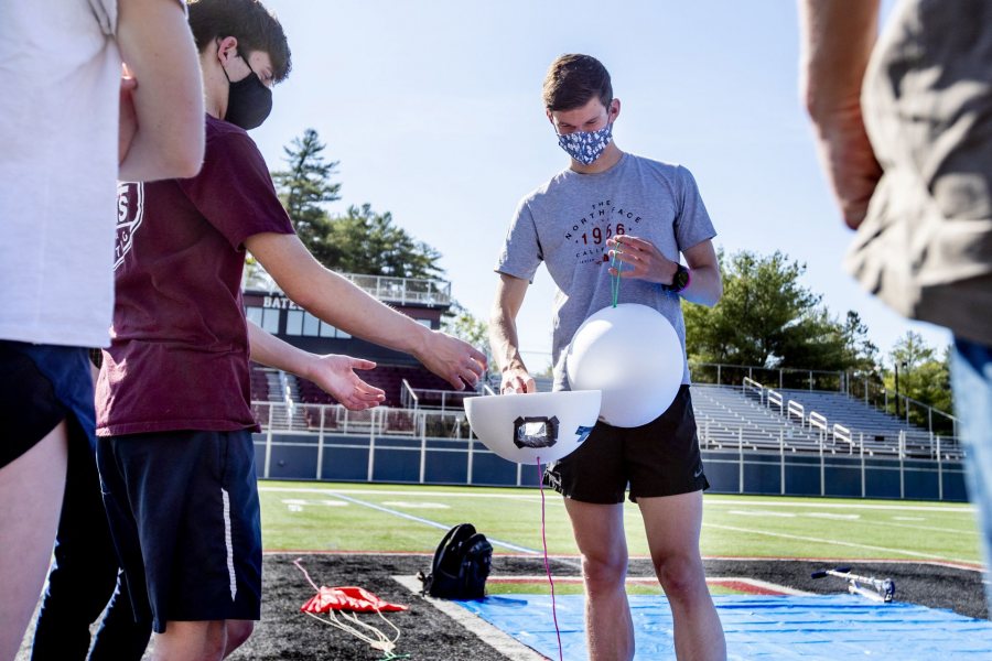 Preparing the payload, Matt Clayton '22 (left) of Wayland, Mass., and Max Bartely '22 (right) of Presque Isle, Maine, test  the gyroscope before attaching the GPS. (Phyllis Graber Jensen/Bates College)